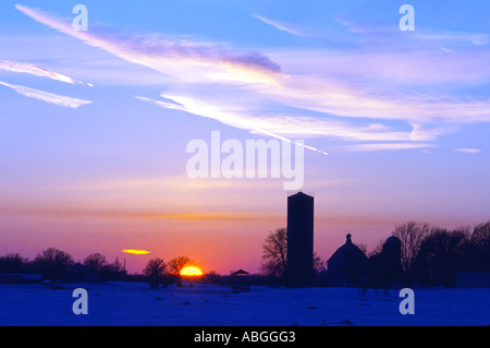 Le soleil disparaît derrière une ferme familiale dans la campagne du Minnesota. Banque D'Images