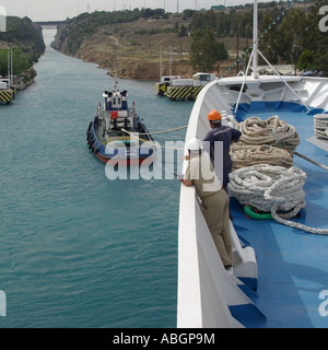 Bateau de croisière en passant par l'étroit canal de Corinthe aidé par le remorqueur Péloponnèse, Grèce Banque D'Images