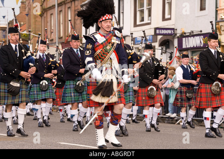 La musique traditionnelle écossaise pipe major avec cornemuses défilent vers le bas Annan High Street Scotland UK Banque D'Images