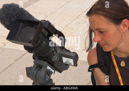 Femme vidéaste de filmer pour BBC television LCD de contrôle sur l'appareil photo Banque D'Images