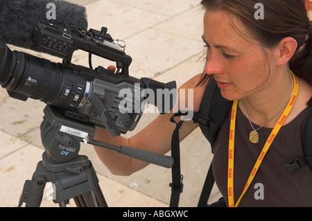 Femme vidéaste de filmer pour BBC Television moniteur LCD de contrôle sur l'appareil photo Banque D'Images