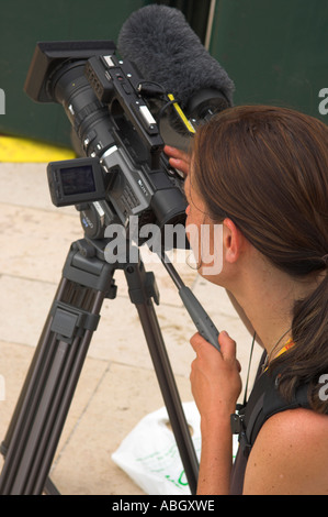 Femme vidéaste de filmer pour BBC Television moniteur LCD de contrôle sur l'appareil photo Banque D'Images