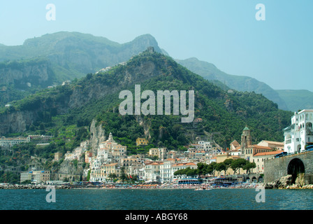 Ville d'Amalfi et bâtiments de bord de mer fort historique et clocher de la cathédrale flanc de coteau verdure en toile de fond vue sur le rivage de la mer Tyrrhénienne Italie Banque D'Images