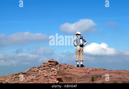 Homme seul walker avec les mains sur les hanches à la recherche en vue du sommet de Brecon Beacons Cribyn Powys Pays de Galles UK Banque D'Images