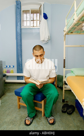 Détenu assis sur fauteuil lecture dans sa cellule de la prison de Cardiff South Wales UK CETTE IMAGE DOIT ÊTRE UTILISÉ DE MANIÈRE POSITIVE Banque D'Images