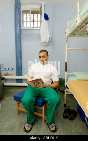 Détenu assis sur fauteuil lecture dans sa cellule de la prison de Cardiff South Wales UK CETTE IMAGE DOIT ÊTRE UTILISÉ DE MANIÈRE POSITIVE Banque D'Images