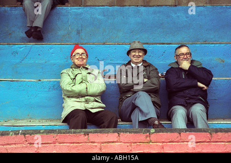 Trois hommes âgés de regarder un match de rugby à Senghenydd Rugby Football Club Mid Glamorgan South Wales UK Banque D'Images