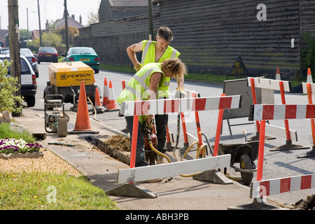 Les travailleurs de la route de creuser une tranchée pour l'installation de câbles à Stow Road à Ixworth, Suffolk, UK Banque D'Images