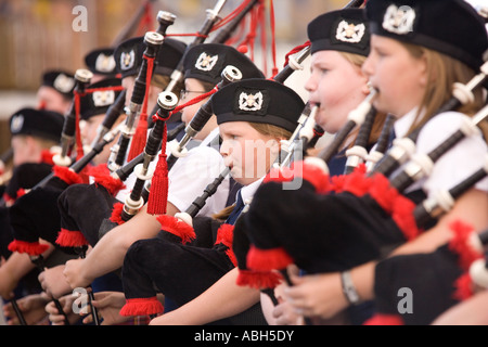 Pipe Band de jeunes enfants jouant la cornemuse sur Annan High Street partie de la circonscription d'Annan les marches en Écosse Banque D'Images