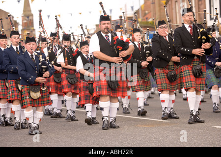 Sac de musique traditionnelle écossaise cornemuse cornemuses défilent vers le bas Annan High Street Scotland UK Banque D'Images