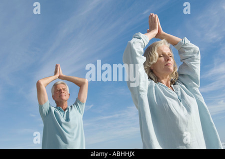 Couple dans l'attitude de yoga sur la plage, à l'extérieur Banque D'Images