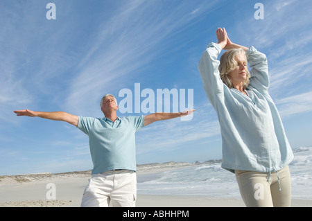 Couple dans l'attitude de yoga sur la plage, à l'extérieur Banque D'Images