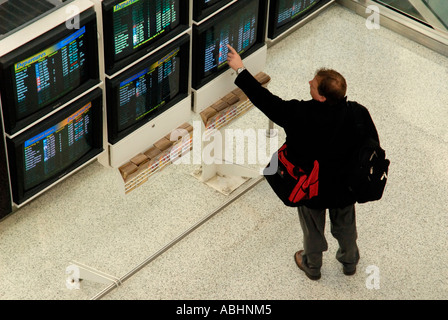 Voyageur Voyageur à pointant à l'aéroport de départ du vol d'informations Banque D'Images