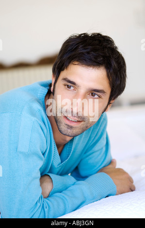 Young man lying on bed Banque D'Images