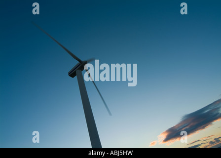 Une image concernant l'énergie des moulins à vent qui se profile sur une côte anglaise tourné au coucher du soleil avec un ciel bleu profond et un effet de flou Banque D'Images