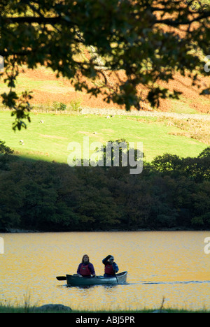 Canoës flottent doucement sur le lac de la lande au coucher du soleil sur une glorieuse atumn journée dans le district d'english lake montagnes ensoleillées Banque D'Images