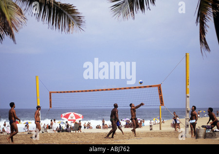 Rio de Janeiro, Brésil. Les jeunes hommes jouer au volley sur la plage de Copacabana. Banque D'Images