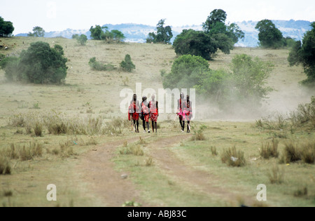 Lolgorian, au Kenya. Groupe de guerriers portant des rouge traditionnel Moran shukka tours de piste à l'Eunoto venant de cérémonie de l'âge. Banque D'Images