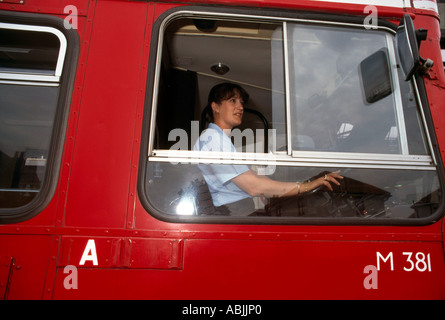 Femme chauffeur de bus avec les mains sur la roue Banque D'Images