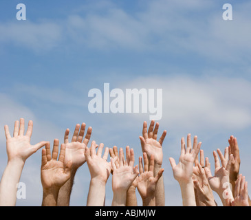 Les mains levées sous ciel bleu Banque D'Images
