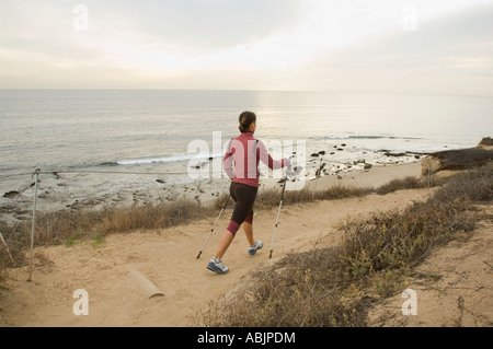 Pôle Hispanic woman walking along coast en Californie United States Banque D'Images