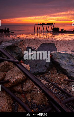 L'aube à Happisburgh sur la côte de Norfolk montrant les défenses maritimes battues Banque D'Images