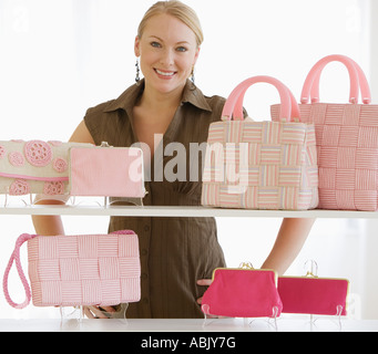 Femme derrière étagères de sacs Banque D'Images