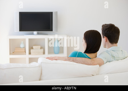 Couple watching television on sofa Banque D'Images