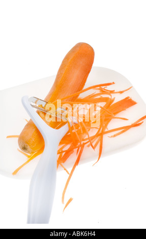 Nouveau moderne et son design ergonomique ergonomique ergonomique éplucheuse de pommes de terre peler une carotte en plastique sur une planche à découper Banque D'Images