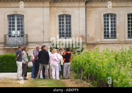 Un groupe de dégustateurs de vins en visite dans les vignobles avec le guide et gesticulant le château bâtiment en arrière-plan Le Château Bouscaut Cru Classe Cadaujac Graves Pessac-Léognan Bordeaux Gironde Aquitaine France Banque D'Images