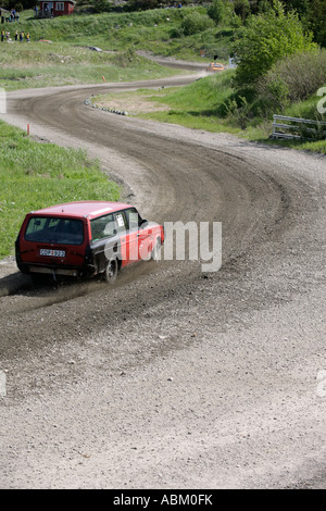 Une voiture sur la route de gravier pays avec plusieurs virages. Banque D'Images