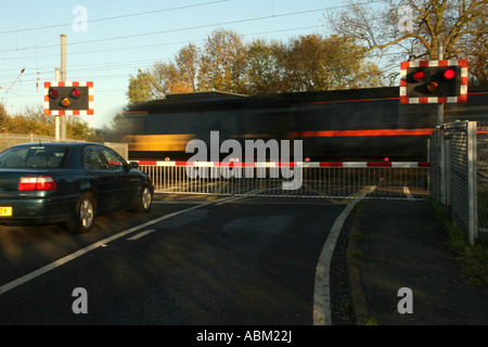 Gner Express train passe en vitesse à travers un passage à niveau Banque D'Images