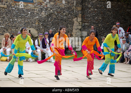 Danseurs Bhangra à la Winchester Mayfest avec Morris Dancers assis à les regarder Banque D'Images