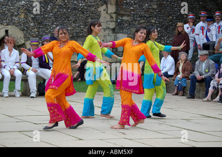 Danseurs Bhangra à la Winchester Mayfest surveillé par d'autres artistes. Banque D'Images