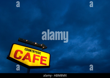 Café Bleu Jaune signe contre ciel orageux Banque D'Images