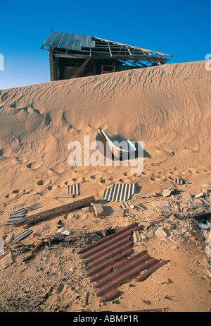 L'épave d'une maison abandonnée engloutis par les dunes de la ville fantôme de Kolmanskop près de Luderitz en Namibie Banque D'Images