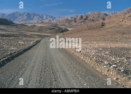 Longue ligne droite de gravier à travers un paysage montagneux des Rocheuses Nord Cap Afrique du Sud Banque D'Images