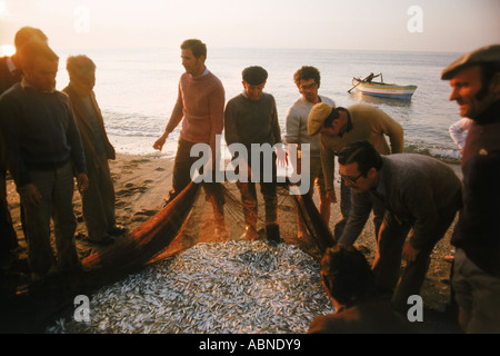 Les pêcheurs espagnols sur la côte de sable de la Méditerranée à Costa del Sol avec filet poisson dans la lumière du matin Banque D'Images