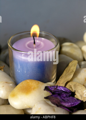 Violet et bleu bougie allumée et dans un récipient en verre Banque D'Images