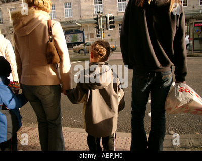 Jeune garçon attendait avec sa mère à traverser la rue à un passage pelican West Wales Aberystwyth, Ceredigion Banque D'Images