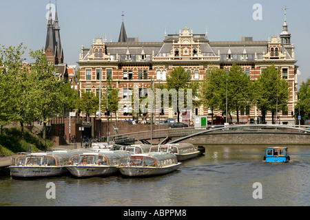 Bateaux de touristes amarré sur l'un des nombreux canaux d'Amsterdam, Hollande. Banque D'Images