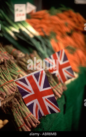 Drapeaux Union Jack parmi les asperges, les poireaux et les carottes sur l'affichage à Borough Market, Southwark, Londres, Angleterre Banque D'Images