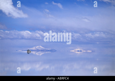 Dans tout excès de sel de la Salar de Uyuni dans un 4x4 cône enneigé du volcan Thunupa éteint la Bolivie s'Amérique Banque D'Images