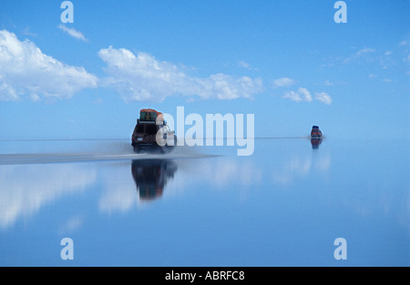 Dans tout excès de sel de la Salar de Uyuni dans un 4x4 réflexions incroyable du ciel dans l'eau en Bolivie s'Amérique Banque D'Images