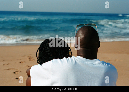 Jeune couple assis sur la plage de la côte nord de l'Afrique du Sud Kwa Zulu Natal Banque D'Images