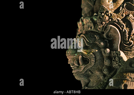 Un démon hindou Rakasa mythique gardien avec de longues dents et grand club à l'entrée du temple Ubud Bali Indonésie fond noir Banque D'Images