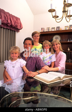 Famille Américaine de passer du temps ensemble autour de la table de la lecture de la bible à la maison Banque D'Images