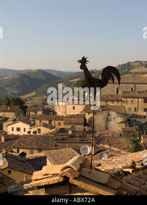 Black metal girouette coq sur le toit au-dessus de la vue de Montone Italie Ombrie hilltown Banque D'Images