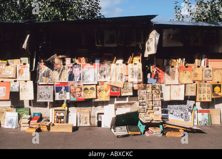 Paris sur le trottoir de la rive gauche près de la Seine un kiosque livre anciens magazines, cartes postales et journaux exposés. Banque D'Images