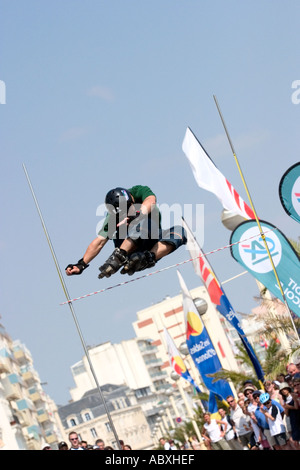 Roller skater jumping high bar Banque D'Images